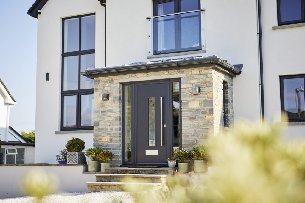 A sleek modern home featuring a large composite front door with a central window.