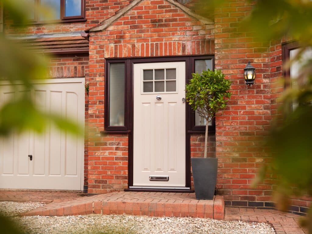 A brick house featuring a white composite front door.